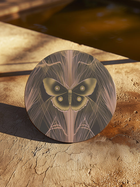 Round ceramic coaster featuring golden Luna moth illustration on dark green background with rose gold linear patterns. Cork-backed, 4-inch diameter. Perfect for vintage nature and gothic decor enthusiasts.